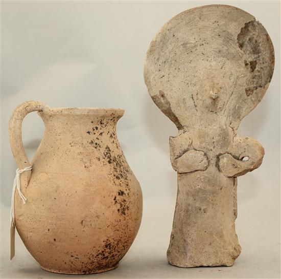 A Greek Cypriot terracotta figure of a goddess, 4th century BC and a Roman terracotta jug, c.2nd century AD, 20.5cm and 13cm